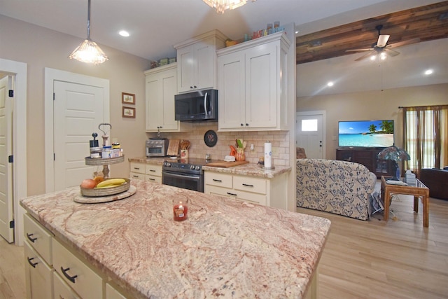 115 Pr 5250, Warren, TX 77664 - kitchen featuring appliances with stainless steel finishes, open floor plan, light wood-type flooring, decorative backsplash, and light stone counters