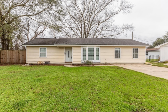 ranch-style house with concrete driveway, a front lawn, and fence