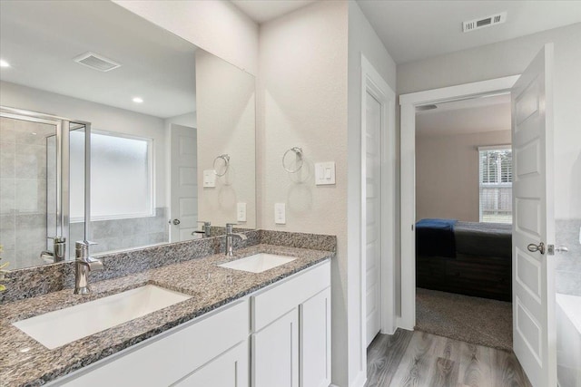 bathroom featuring a shower with door, vanity, and hardwood / wood-style floors