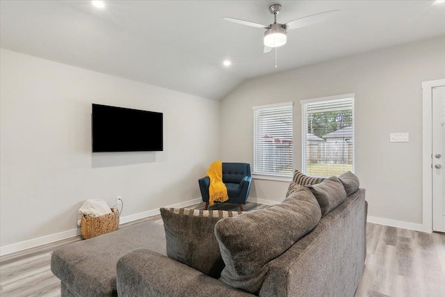 living room with ceiling fan, vaulted ceiling, and light hardwood / wood-style flooring