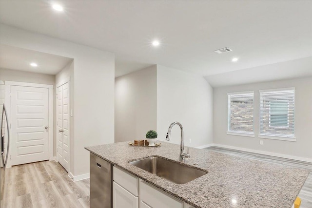 kitchen featuring sink, dishwasher, white cabinetry, light stone countertops, and light wood-type flooring