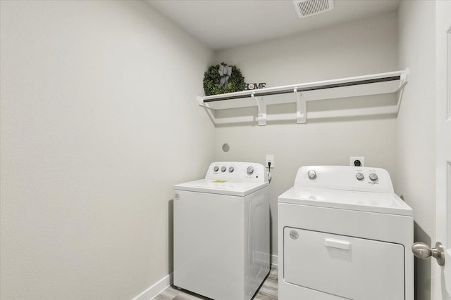 washroom featuring light hardwood / wood-style floors and washer and dryer