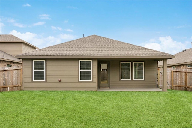 rear view of property with a yard and a patio area