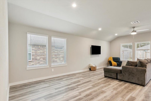 living room with ceiling fan, vaulted ceiling, and light hardwood / wood-style flooring