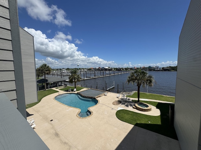 view of swimming pool featuring a boat dock, a patio, and a water view