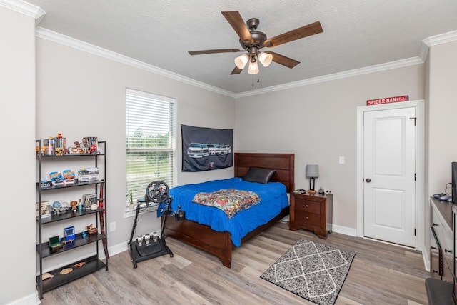 bedroom featuring crown molding, light wood finished floors, and baseboards