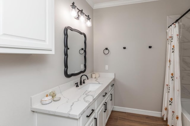 bathroom featuring baseboards, shower / tub combo, wood finished floors, vanity, and ornamental molding