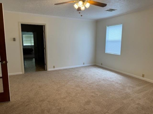 carpeted empty room featuring ceiling fan, plenty of natural light, and a textured ceiling