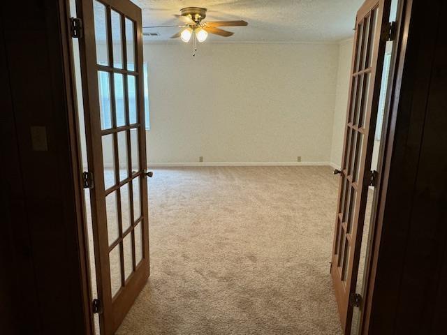 unfurnished room featuring light carpet, french doors, and ceiling fan