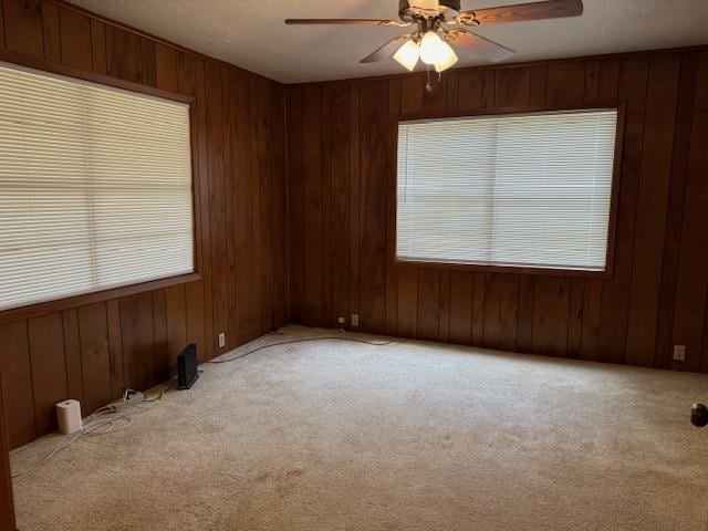 carpeted empty room featuring ceiling fan and a textured ceiling