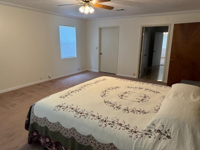 bedroom with carpet floors, ceiling fan, and ornamental molding