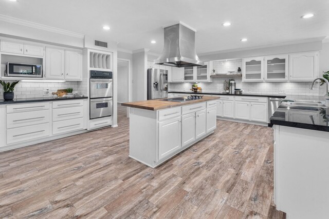 kitchen with island exhaust hood, white cabinetry, and stainless steel appliances