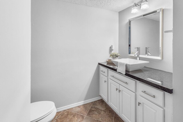 bathroom with vanity, a textured ceiling, and toilet