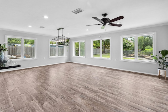 interior space with ceiling fan with notable chandelier, light hardwood / wood-style flooring, and ornamental molding