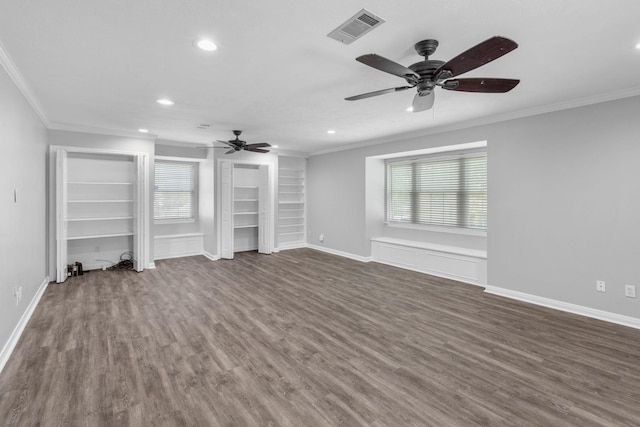 unfurnished living room with built in shelves, crown molding, and a healthy amount of sunlight