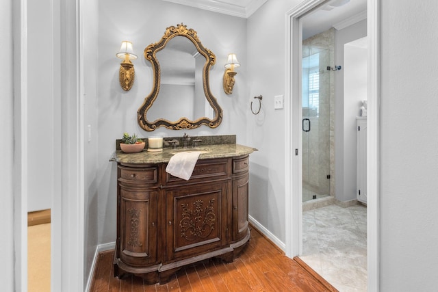 bathroom featuring hardwood / wood-style floors, vanity, ornamental molding, and walk in shower