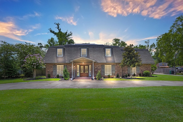 front facade featuring french doors and a yard