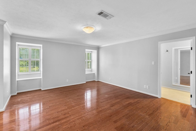 empty room with hardwood / wood-style flooring, a healthy amount of sunlight, and ornamental molding