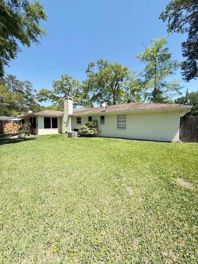 215 Wildwood Dr, Village Mills, TX 77663 - back of house with fence, a lawn, and a chimney