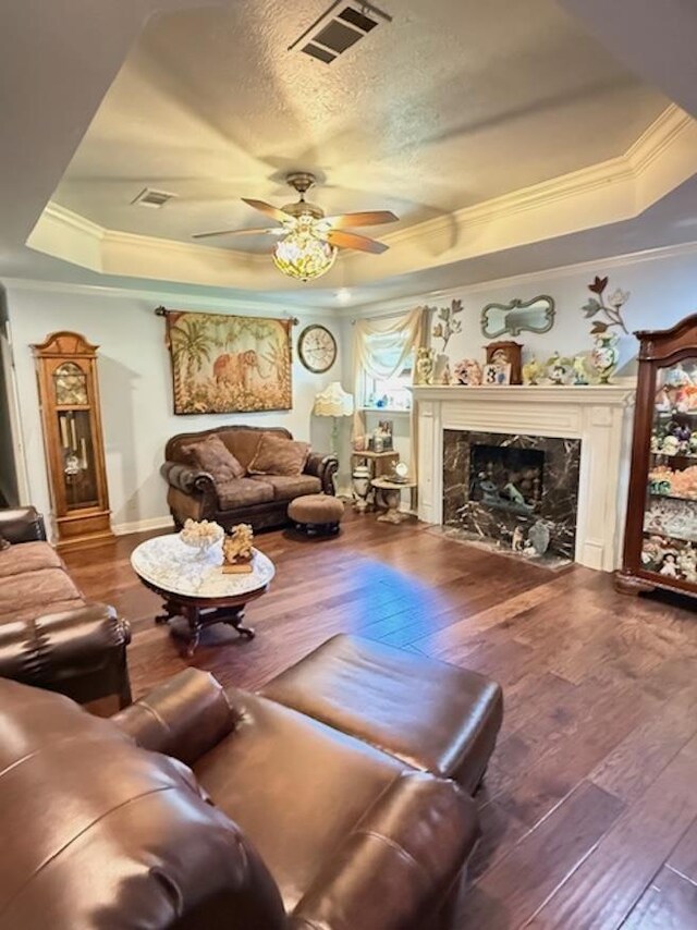 215 Wildwood Dr, Village Mills, TX 77663 - living room featuring hardwood / wood-style flooring, visible vents, a tray ceiling, and ornamental molding