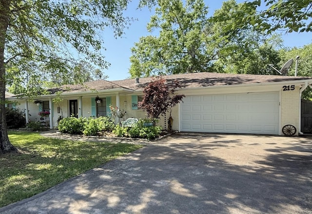 215 Wildwood Dr, Village Mills, TX 77663 - ranch-style house featuring brick siding, a front lawn, a garage, and driveway