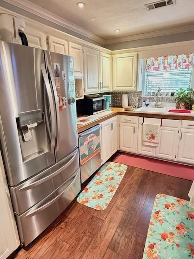 215 Wildwood Dr, Village Mills, TX 77663 - kitchen featuring dark wood-style flooring, light countertops, crown molding, visible vents, and stainless steel appliances