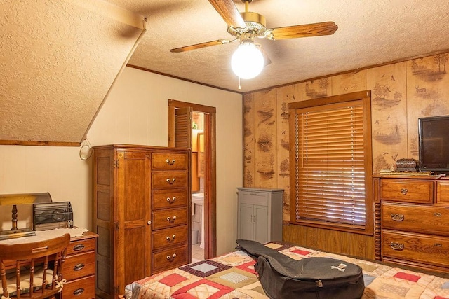 bedroom with wood walls, crown molding, ceiling fan, and a textured ceiling