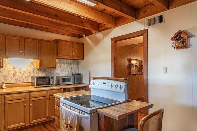 kitchen featuring backsplash, white range with electric stovetop, dark wood-type flooring, beam ceiling, and butcher block counters