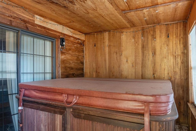 interior space with wooden ceiling, a jacuzzi, and wooden walls