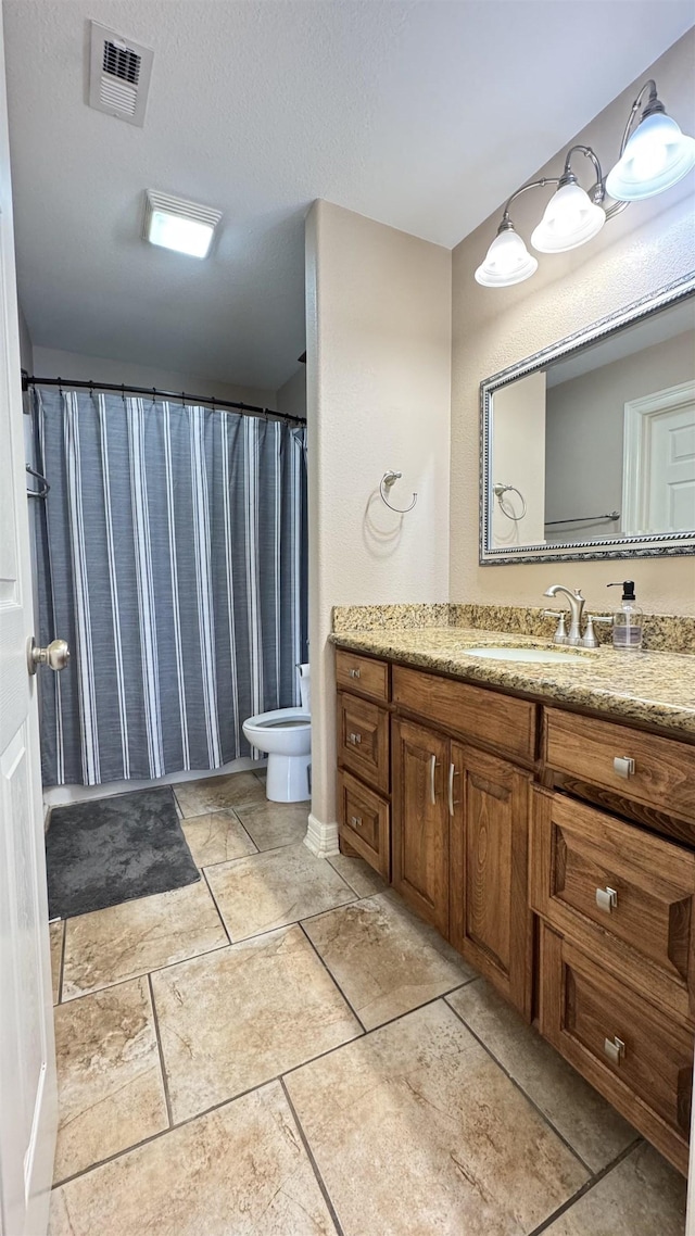 full bathroom with toilet, visible vents, a textured ceiling, and vanity