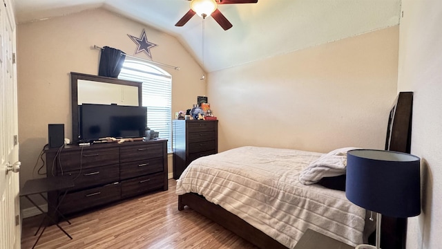 bedroom with lofted ceiling, light wood-style flooring, and a ceiling fan