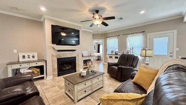 living room featuring ceiling fan, a fireplace, visible vents, and crown molding