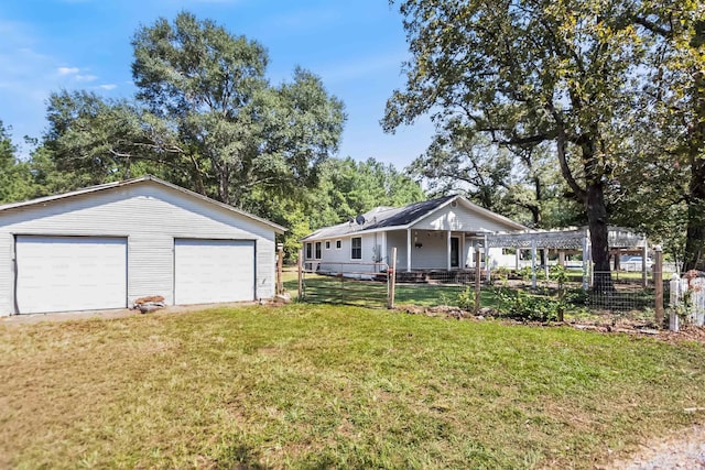 view of front facade featuring a garage, an outbuilding, fence, and a front lawn