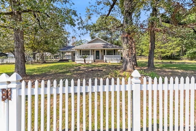 view of front facade with covered porch, a fenced front yard, and a front yard