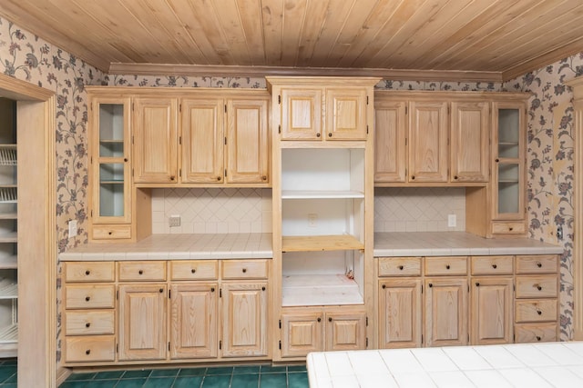 kitchen with tile counters, wood ceiling, light brown cabinets, and wallpapered walls