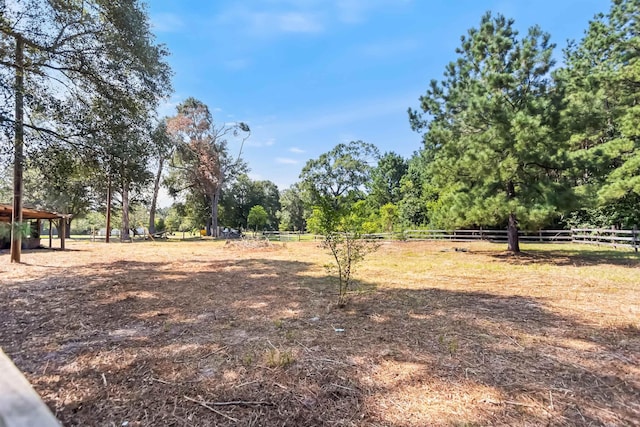 view of yard featuring a rural view and fence