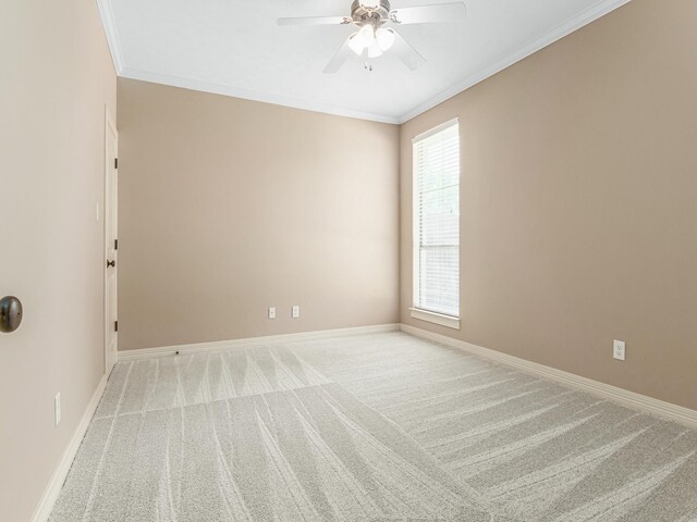 empty room featuring ceiling fan, crown molding, and light carpet