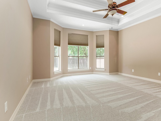 unfurnished room with light carpet, a tray ceiling, ceiling fan, and ornamental molding