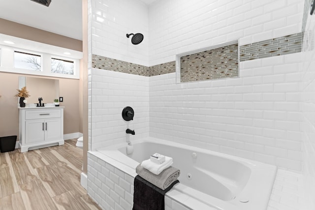 bathroom featuring wood-type flooring and tiled shower / bath