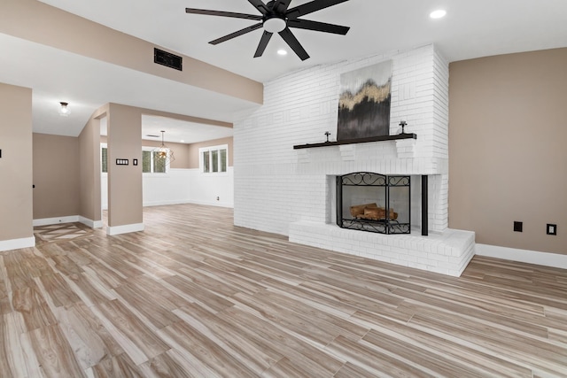 unfurnished living room with ceiling fan, light hardwood / wood-style flooring, and a brick fireplace