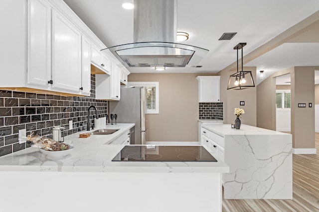 kitchen with sink, white cabinets, backsplash, light stone countertops, and black electric stovetop