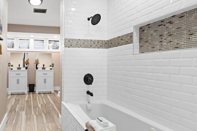 bathroom featuring sink, tiled shower / bath combo, and hardwood / wood-style flooring