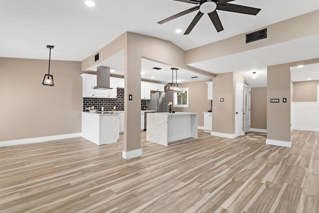 unfurnished living room with lofted ceiling, ceiling fan, and light hardwood / wood-style floors