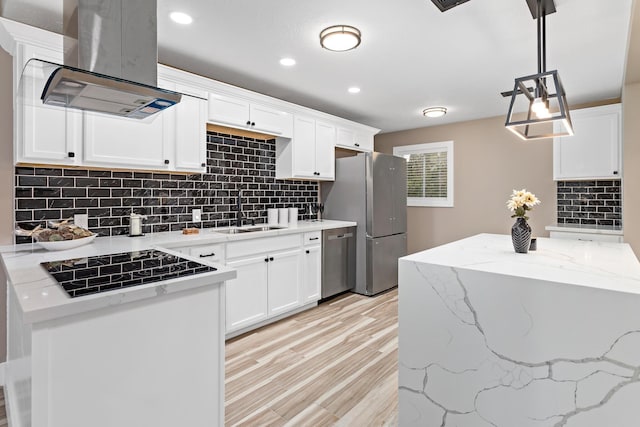 kitchen featuring sink, white cabinetry, island exhaust hood, hanging light fixtures, and appliances with stainless steel finishes