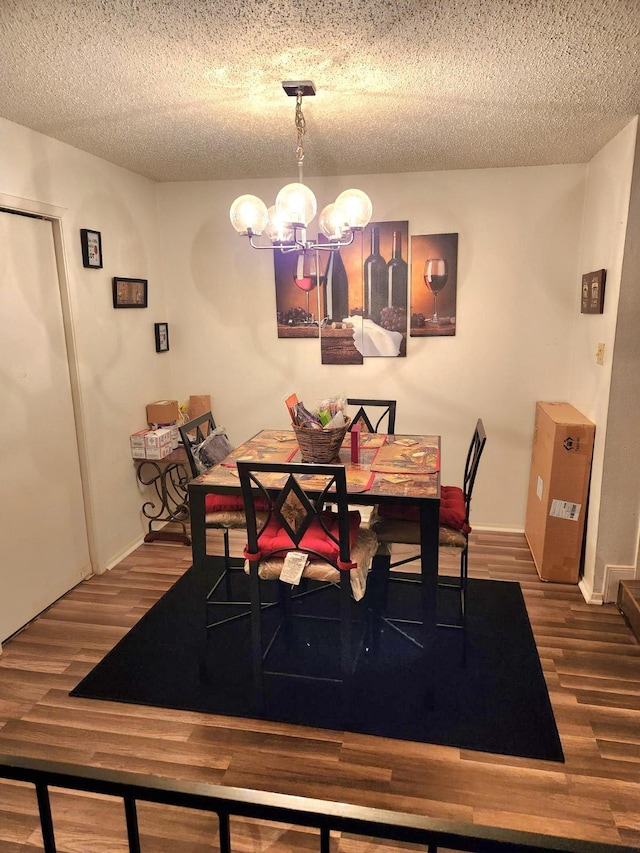 dining area featuring wood-type flooring, a textured ceiling, and a notable chandelier