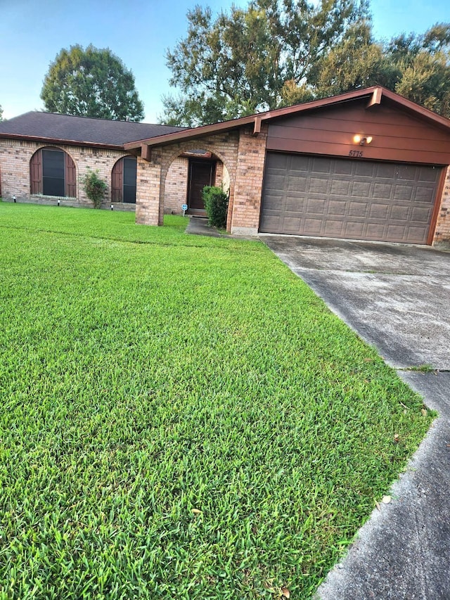 single story home with a front yard and a garage