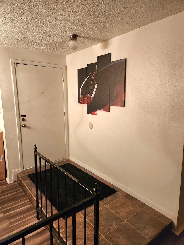 stairway featuring a textured ceiling and tile patterned floors