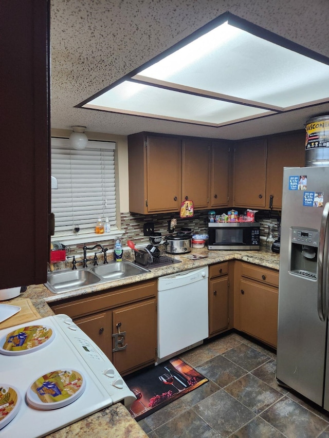 kitchen featuring decorative backsplash, sink, and appliances with stainless steel finishes