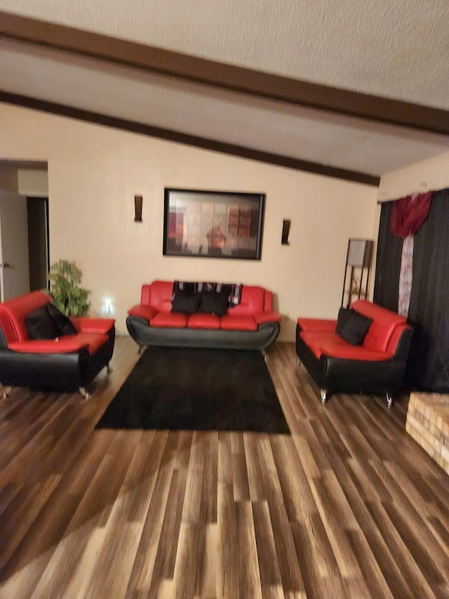 living room featuring beamed ceiling, hardwood / wood-style floors, and a textured ceiling