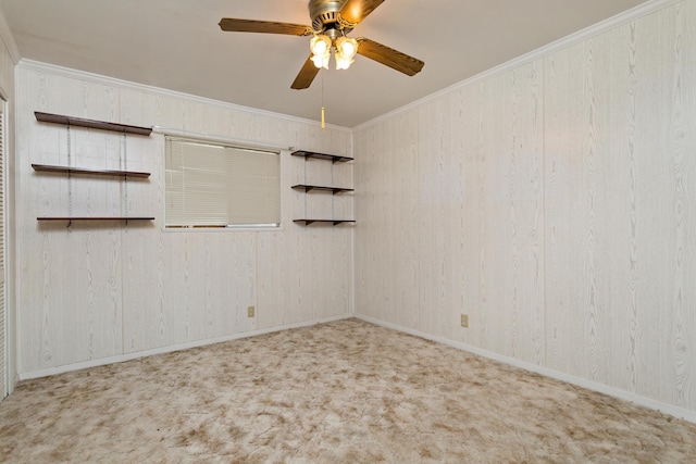 spare room with ceiling fan, carpet flooring, crown molding, and baseboards